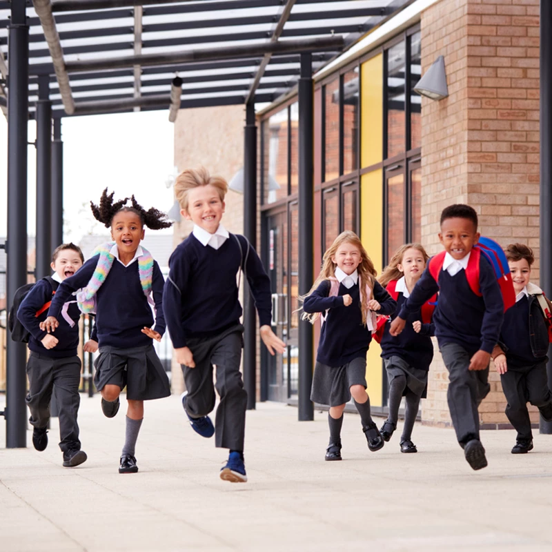 Several children sprinting playfully in front of a building, showcasing their energy and excitement